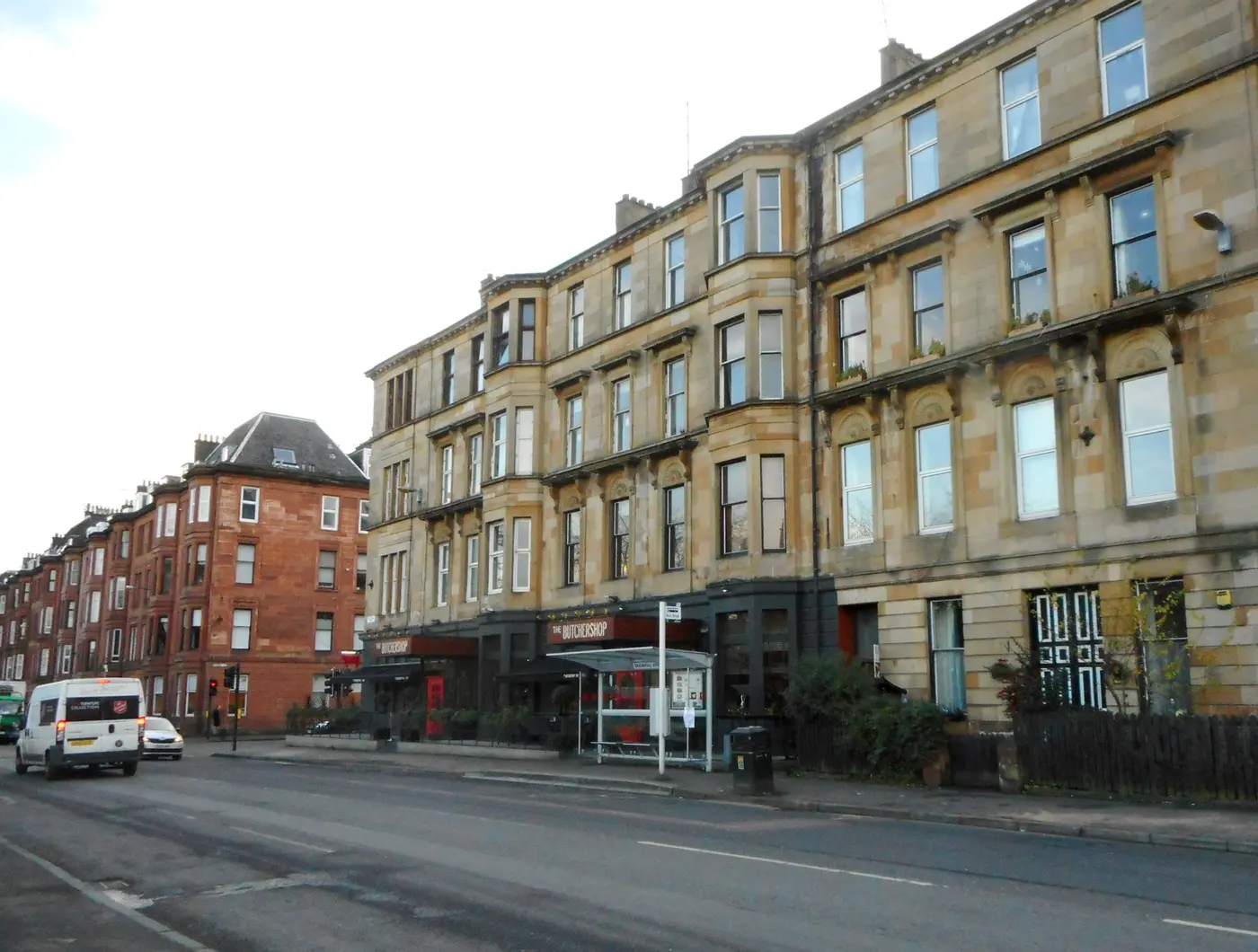 Blonde and red sandstone tenements with projecting bay windows on Sauchiehall Street in Glasgow.
